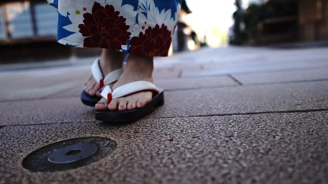 浴衣を着て歩く女性の足元