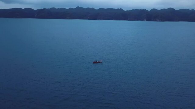 drone shoot of a boat in the middle of the occean with fishingman