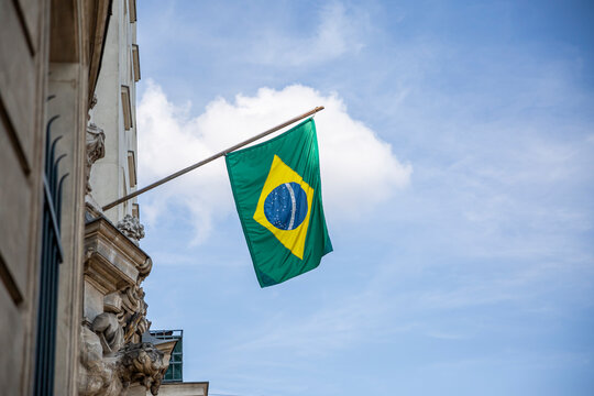 Brazil flag. Brazilian flag displaying on a pole in front of the house. National flag of Brazil waving on a home hanging from a pole on a front door of a building.