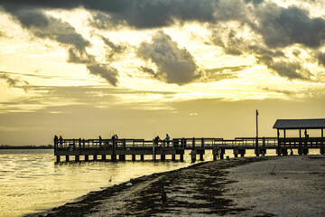 Obraz premium sunset at Sanibel lighthouse park where people are fishing on a dock