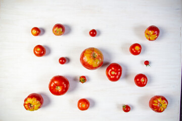 Naklejka na ściany i meble red with yellow tomatos on white wooden background