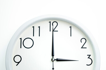 A wall clock that announces 3 o'clock on the hour