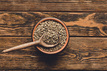 Hemp seed in clay bowl on wooden background