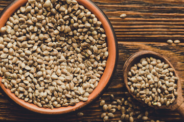 Hemp seed in clay bowl on wooden background