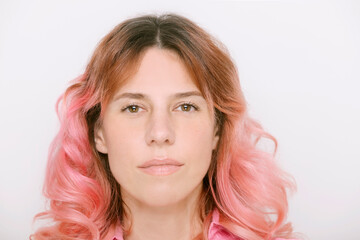 Naklejka premium smiling mature woman with pink hair looking at camera wearing pink dress