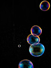 Obraz na płótnie Canvas colored soap bubbles on black background