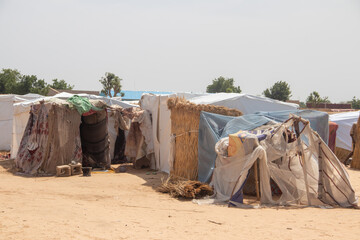 Refugee camp made of local materials and plastic sheeting, people living in very poor conditions,...