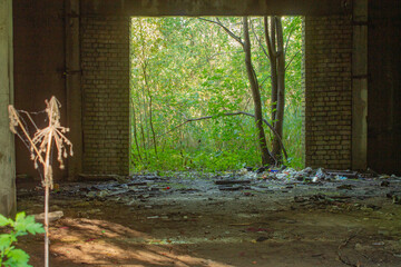 Garbage in an abandoned building. Topic - environmental pollution, ecology. Old abandoned industrial shop turned into garbage dump