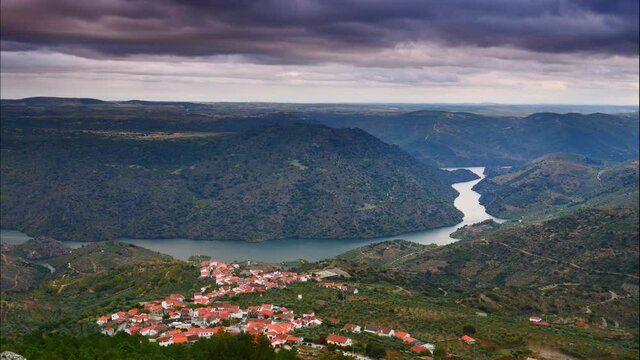 Time lapse of dark stormy clouds moving over Douro river and Mazouco village in northern Portugal. View from Colado viewpoint. Tourist attraction. Place to visit.