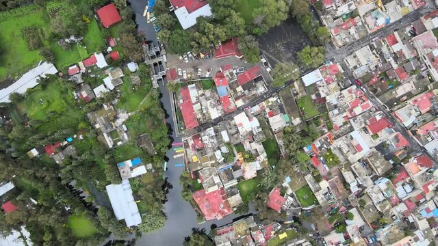 Slowly jib down above houses, chinampas and canal in Xochimilco, Mexico City