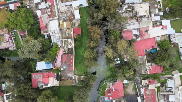 Slowly jib upabove houses and canal in Xochimilco