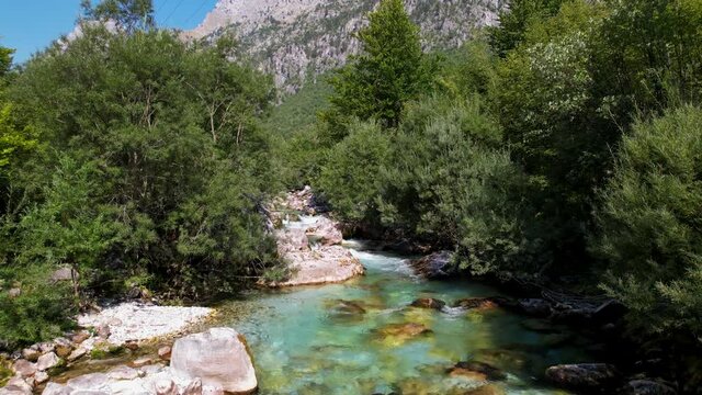 Turquoise water of clean river streaming on beautiful valley of Valbona in Albanian Alps