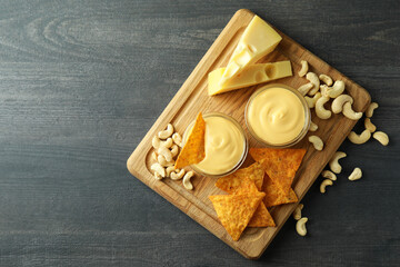 Concept of snack with cheese sauce on dark wooden table, top view