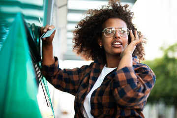 Beautiful African woman using ATM machine. Attractive young woman withdrawing money from credit...