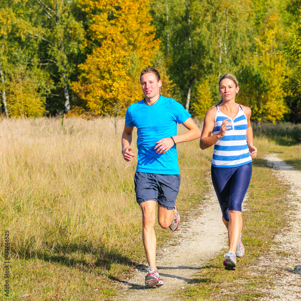 Sticker Joggendes Paar in herbstlicher Landschaft