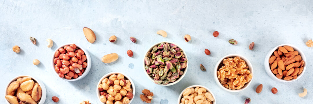 Nuts panoramic banner, overhead flat lay shot onn a slate background with a place for text