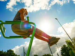 Man doing legs exercises in outdoor gym