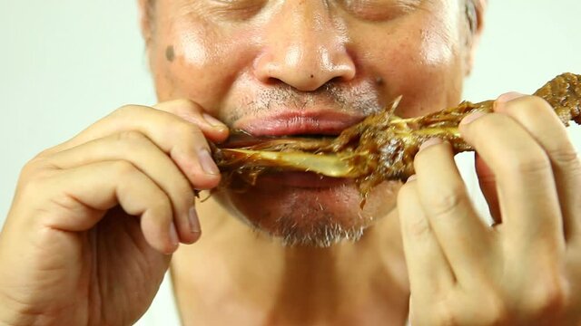 Close up man eating  Pot-stewed duck wing   ,in studio Chiangmai  Thailand.