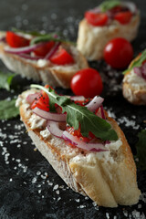 Delicious bruschetta snacks on black smokey background