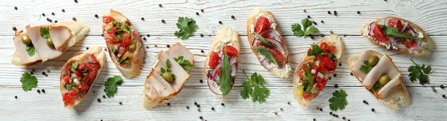Delicious italian snacks bruschetta on white wooden background