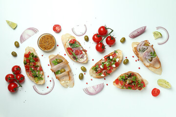 Delicious italian snacks bruschetta and ingredients on white background