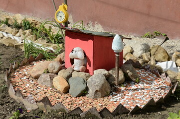 A toy booth with a dog on a flower bed near an apartment building in Kaluga