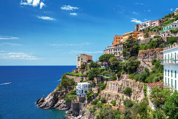 Fototapeta na wymiar Panoramic view of a typical scene on the Amalfi Coast in Italy, where colorful houses are stacked on the rocks jutting into the deep blue sea. 