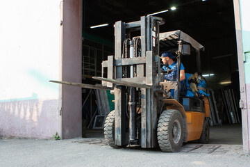 Worker driving forklift and loading glass constructions © Kashper