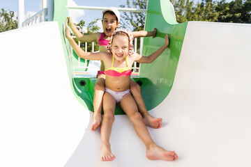 Two little girls fun jumping into the swimming pool