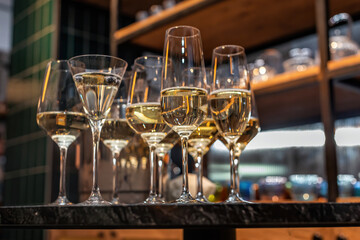 Many different wine glasses on the table. Still life of glasses with alcoholic beverage on the showcase.