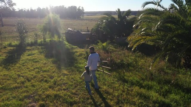 Aerial view of artist with his little daughter walking in the field.