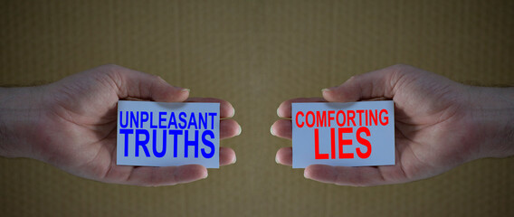unpleasant truths versus conforting lies on cardboards in man's hands, Concept for different...
