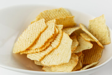 Salty chips in a plate. An appetizing snack. Close-up.