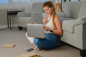 beautiful young woman with laptop at home on the couch. chatting online, lifestyle