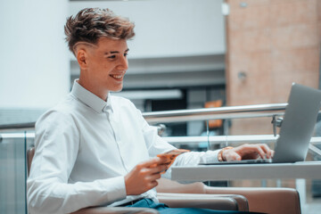 Joven trabajador profesional feliz riendo sentado trabajando con el ordenador de forma profesional