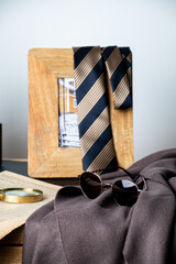 photo frame and tie glasses on brown scarf and magnifier on the old newspaper