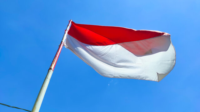 Photo of the red and white flag flying on a pole to celebrate Indonesia's independence day