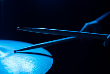 Close-up of drumsticks on a cymbal drum