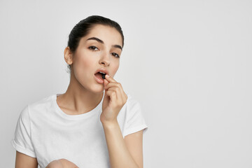 woman in white t-shirt with pills in hands medicine treatment