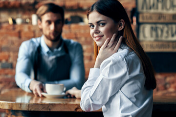 the waiter next to the client brings coffee service Professional