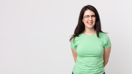 pretty woman looking happy and friendly, smiling and winking an eye at you with a positive attitude