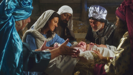 Magi and parents speaking over manger with baby Jesus