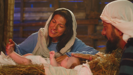 Mary and Joseph kissing and touching baby Jesus