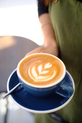 Barita hands holding a Latte art hot coffee drink