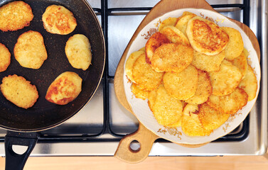 Top view of tasty potato pancakes on a pan and plate, Ukrainian food