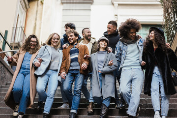Obraz premium Happy diverse friends having fun walking around the city - Focus on center girl face