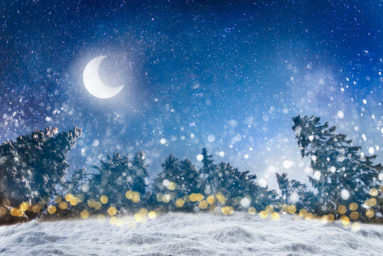 Old winter background for Merry Christmas and Happy New Year with fluffy snowdrifts against background of night winter forest, falling snow and dark sky with moon