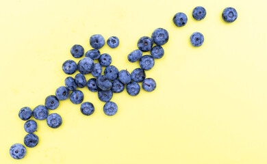 Colorful fruit pattern of blueberries on yellow background. Top view. Flat lay