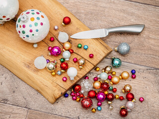 Christmas bauble grinded by knife on wooden surface. Cooking or prepare Christmas, conceptual photo