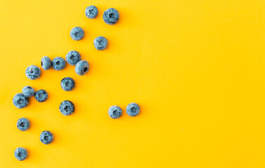 Tasty ripe blueberries on yellow background, flat lay